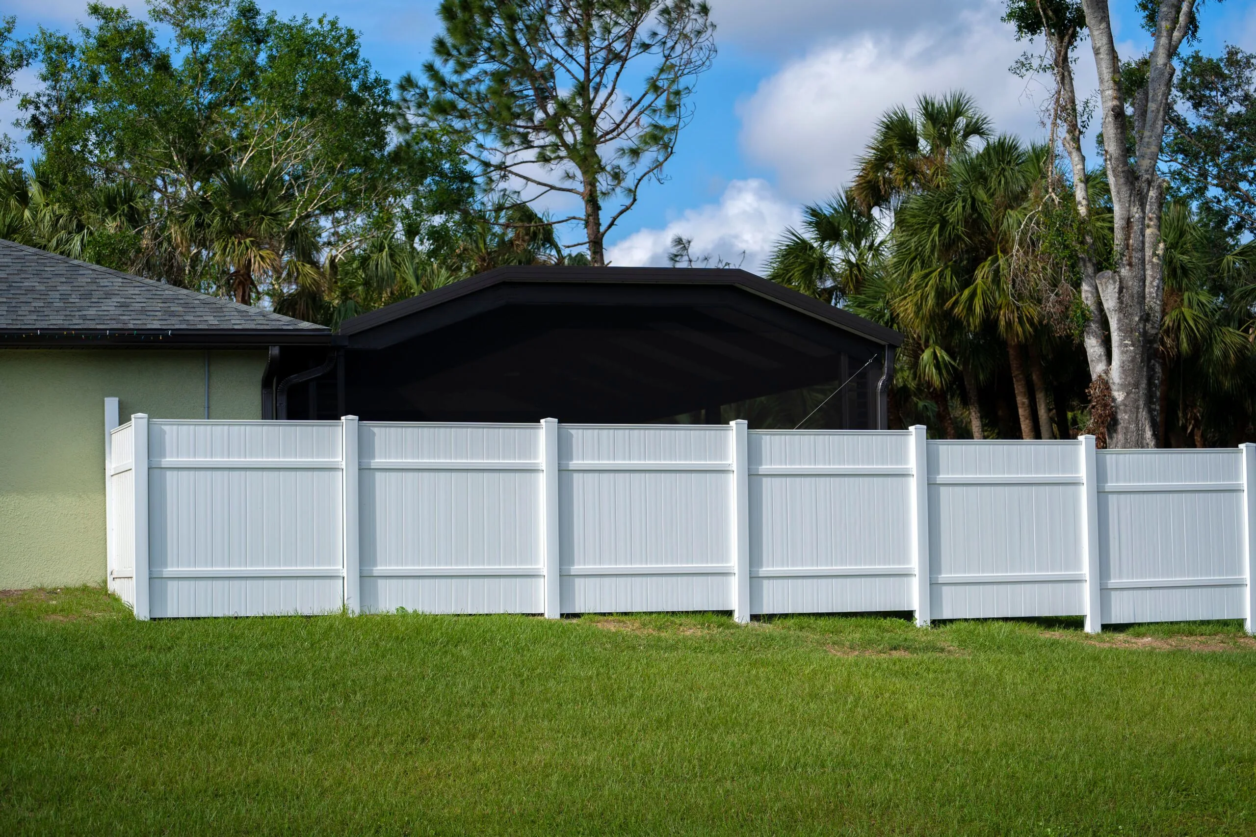 White vinyl picket fence green lawn surrounding property ground