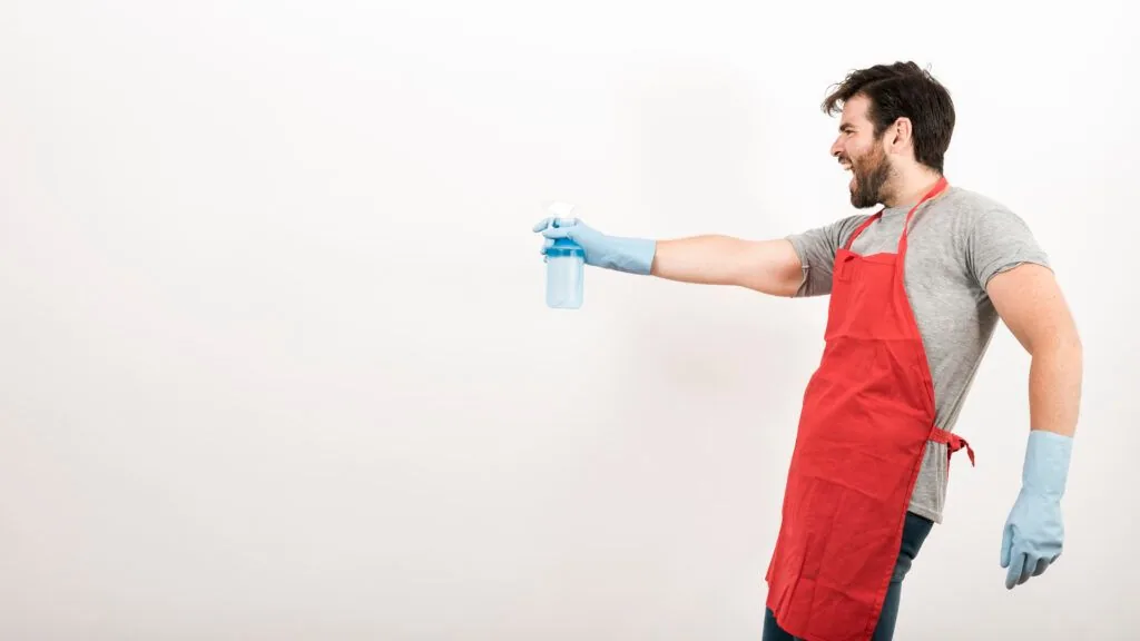 Man cleaning a wall in his home before painting