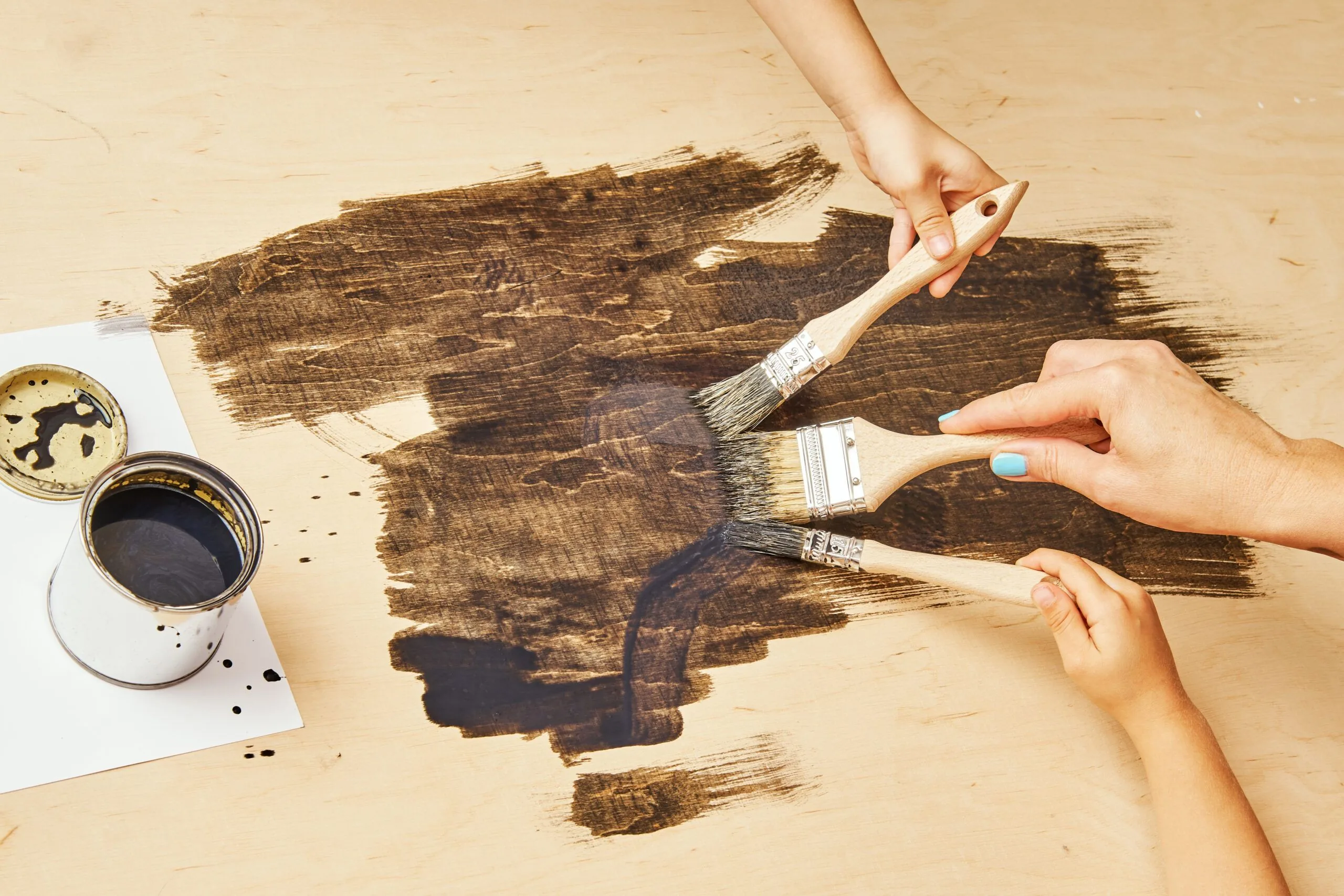 Cropped hands people painting wooden table