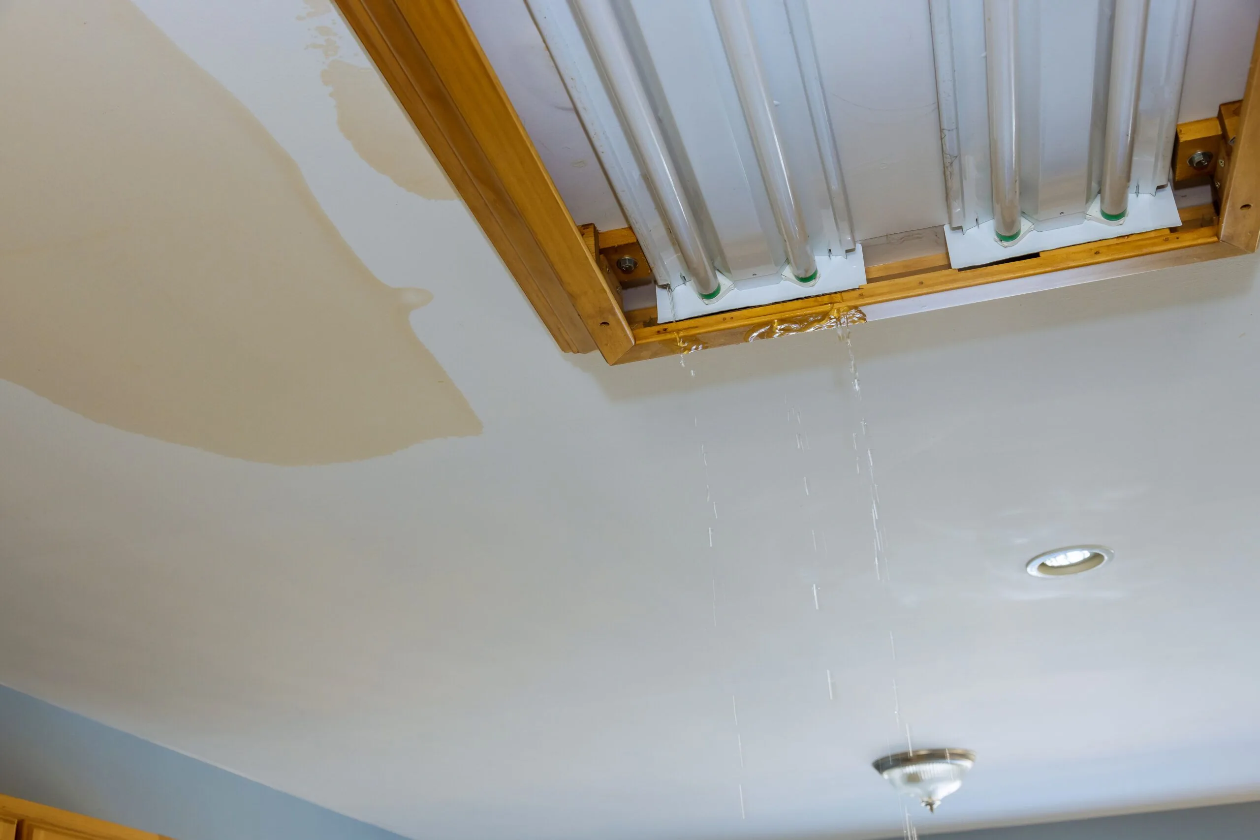 Water leaking through a ceiling light fixture from an upstairs flood