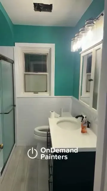 Bathroom repainted in teal with white trim